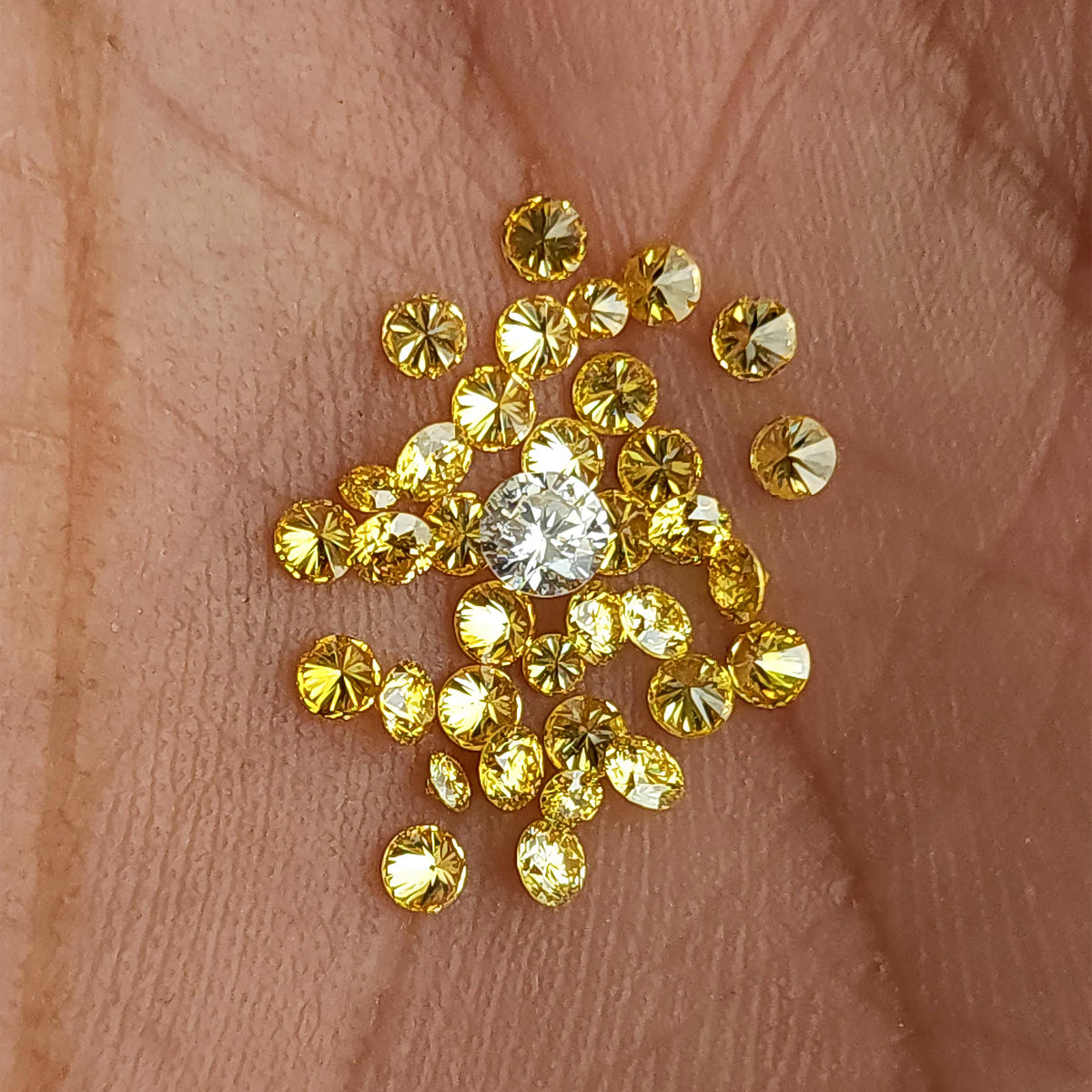 Yellow diamonds resting on a palm with a white comparison diamond, not included.