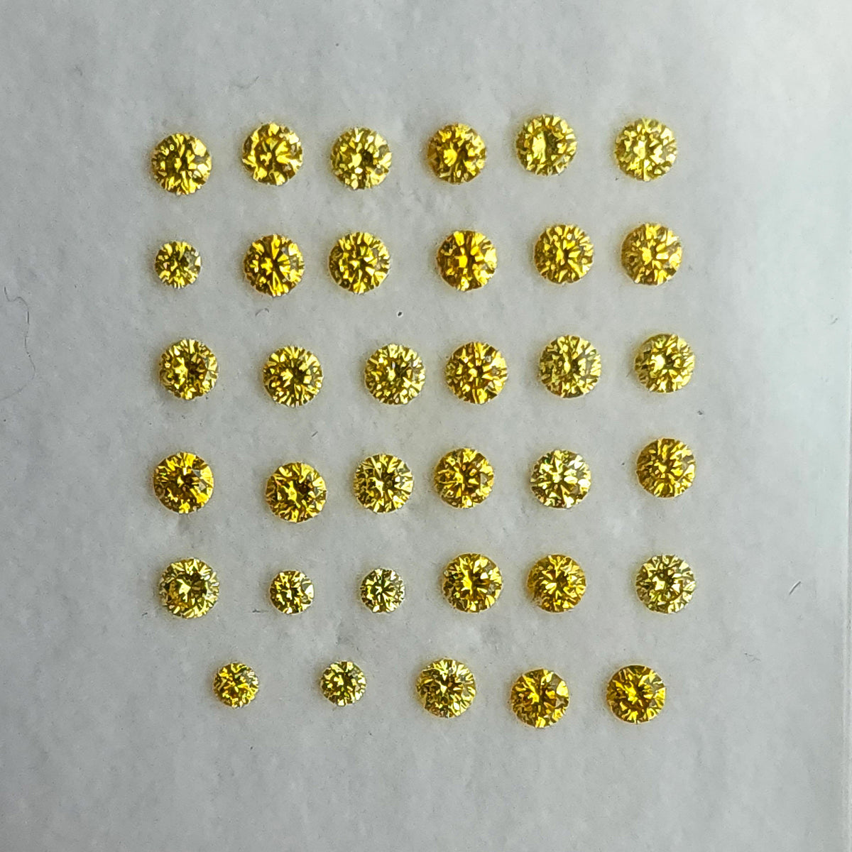 Close face-up yellow diamond rows on a white display pad.