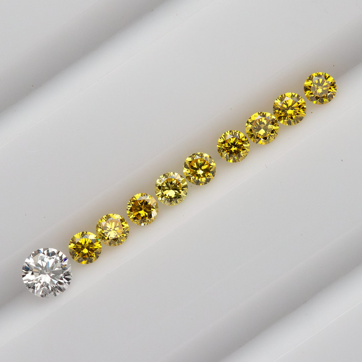 Diagonal yellow diamond lineup on a white tray with an excluded white comparison diamond.