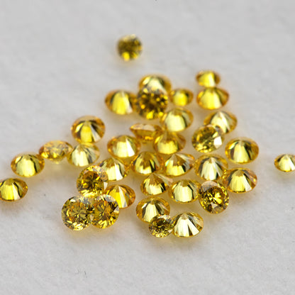Side and face-up views of loose yellow diamonds on a pale surface with an excluded white comparison.