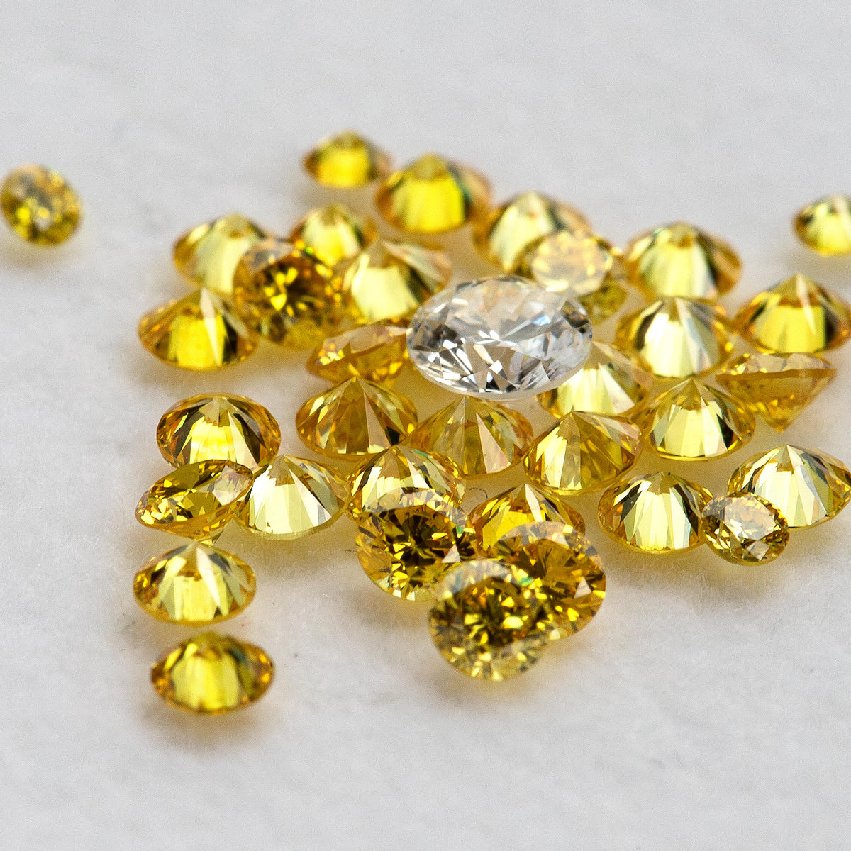 Low-angle yellow diamonds showing side facets beside an excluded white comparison diamond.