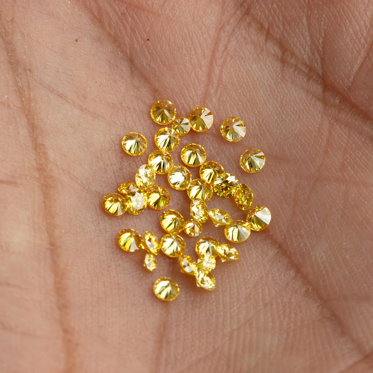 Wider palm view of yellow diamond cluster and an excluded white comparison diamond.