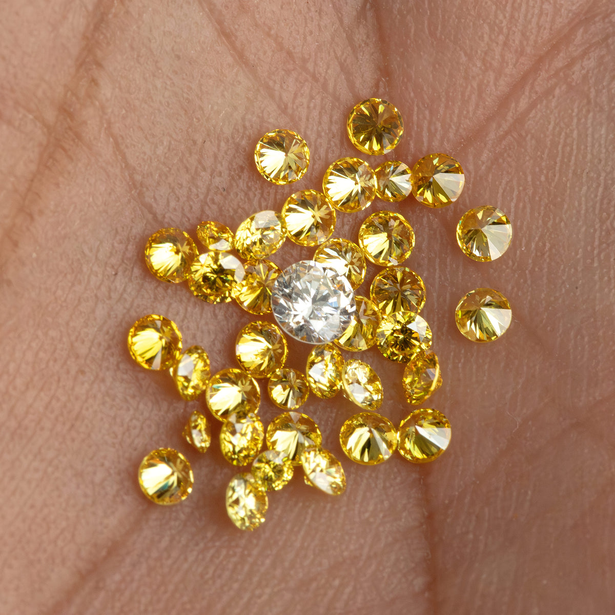 Alternate hand-scale view of yellow diamonds with an excluded white comparison diamond.