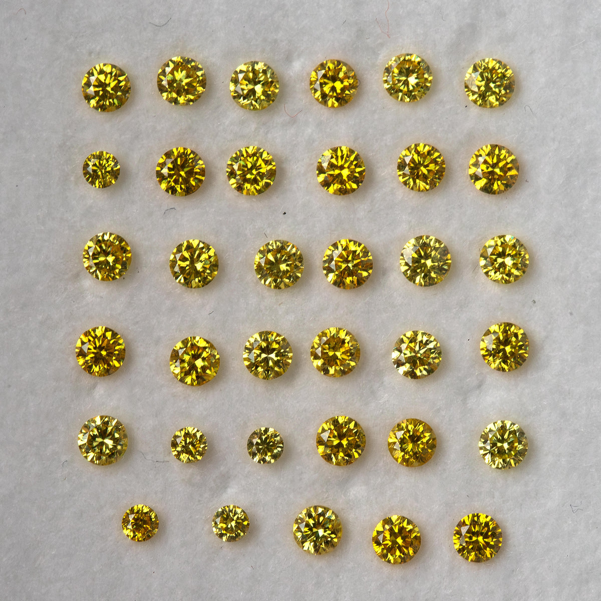 Face-up yellow diamond rows with varied reflections across the visible facets.