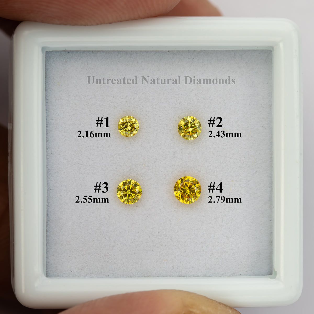 Hand-held numbered tray displaying the four individual yellow diamonds and their sizes.