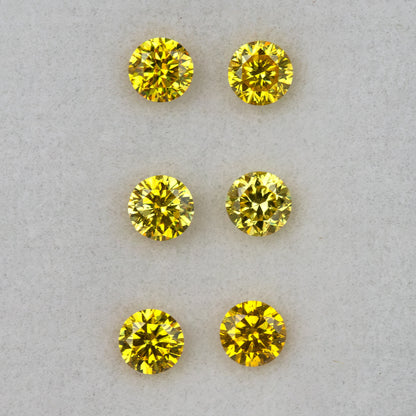 Three yellow diamond pairs arranged in horizontal rows face-up on a pale surface.