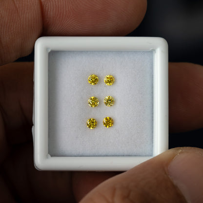 White tray with three yellow diamond pairs held upright in a hand.