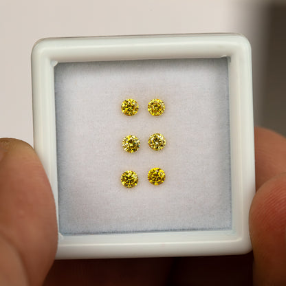 Closer front view of a hand-held white tray showing three yellow diamond pairs.