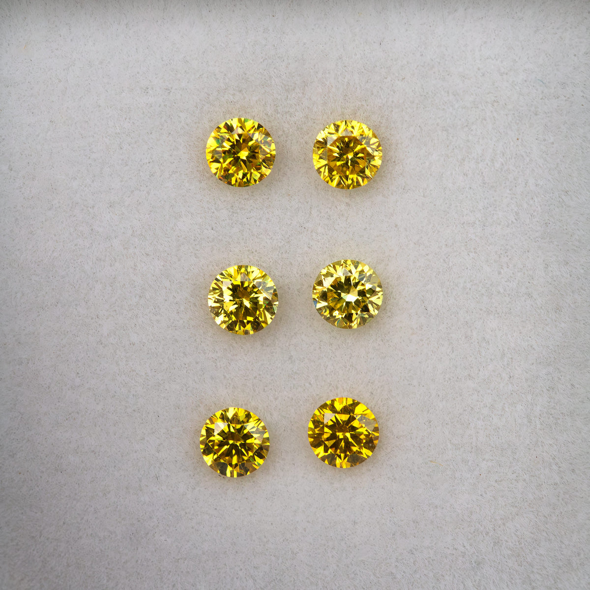 Loose face-up display of three pairs, showing varied yellow reflections.