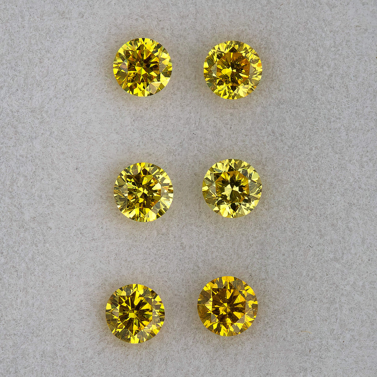 Macro face-up view of three pairs showing their round outlines and facets.