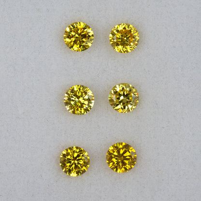 Crisp face-up view of three round brilliant yellow diamond pairs in rows.