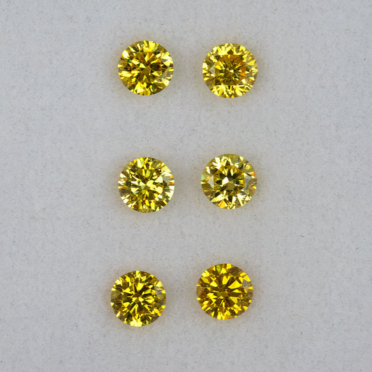 Crisp face-up view of three round brilliant yellow diamond pairs in rows.