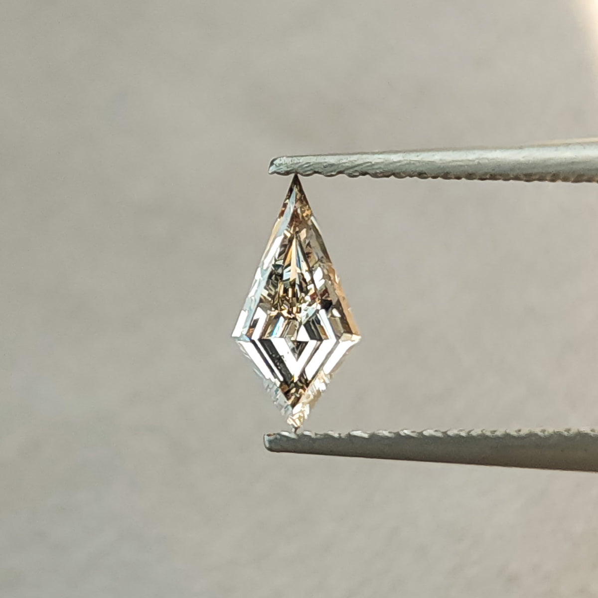 Face-up angle of the elongated kite lab-grown diamond showing dark central contrast and bright geometric facet reflections.