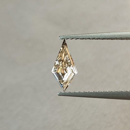 Alternate face-up angle of the elongated kite lab-grown diamond, showing warmer champagne reflections and its long two-pointed outline.