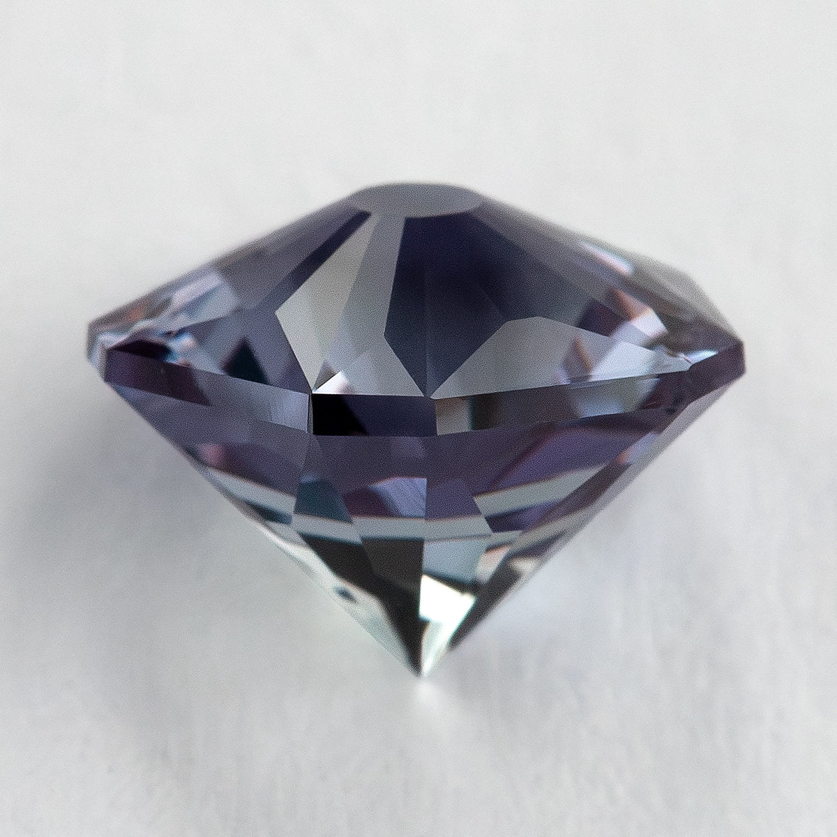 Side-on lab-grown sapphire showing the shallow crown line, girdle and pointed pavilion.