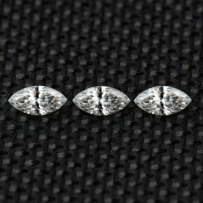 Three face-up marquise diamonds in a horizontal row on black fabric, illustrating the three-piece selection.