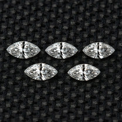 Five face-up marquise diamonds in two rows on black fabric, illustrating the five-piece selection.