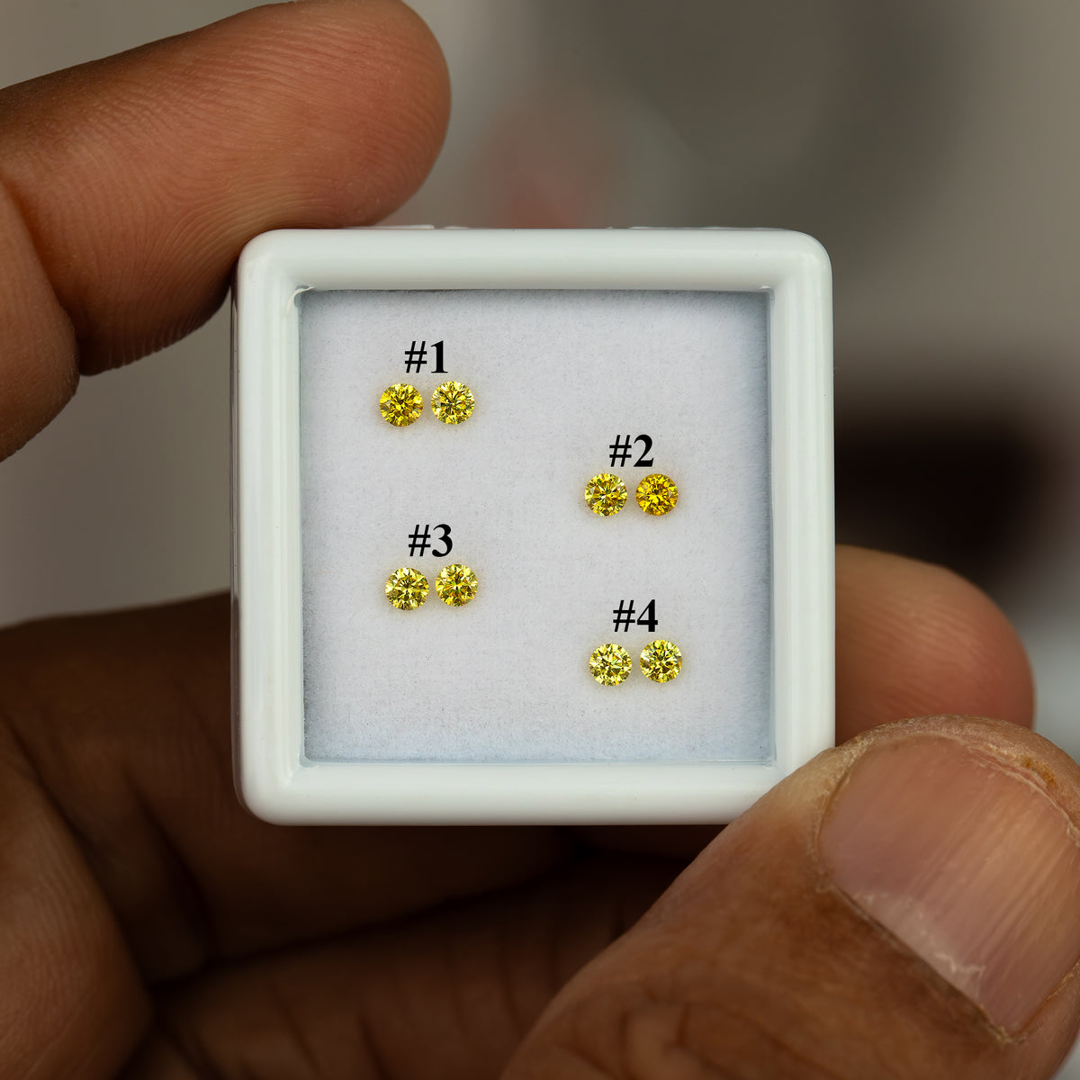 Hand-held white tray identifying the four yellow diamond pairs as #1–4.