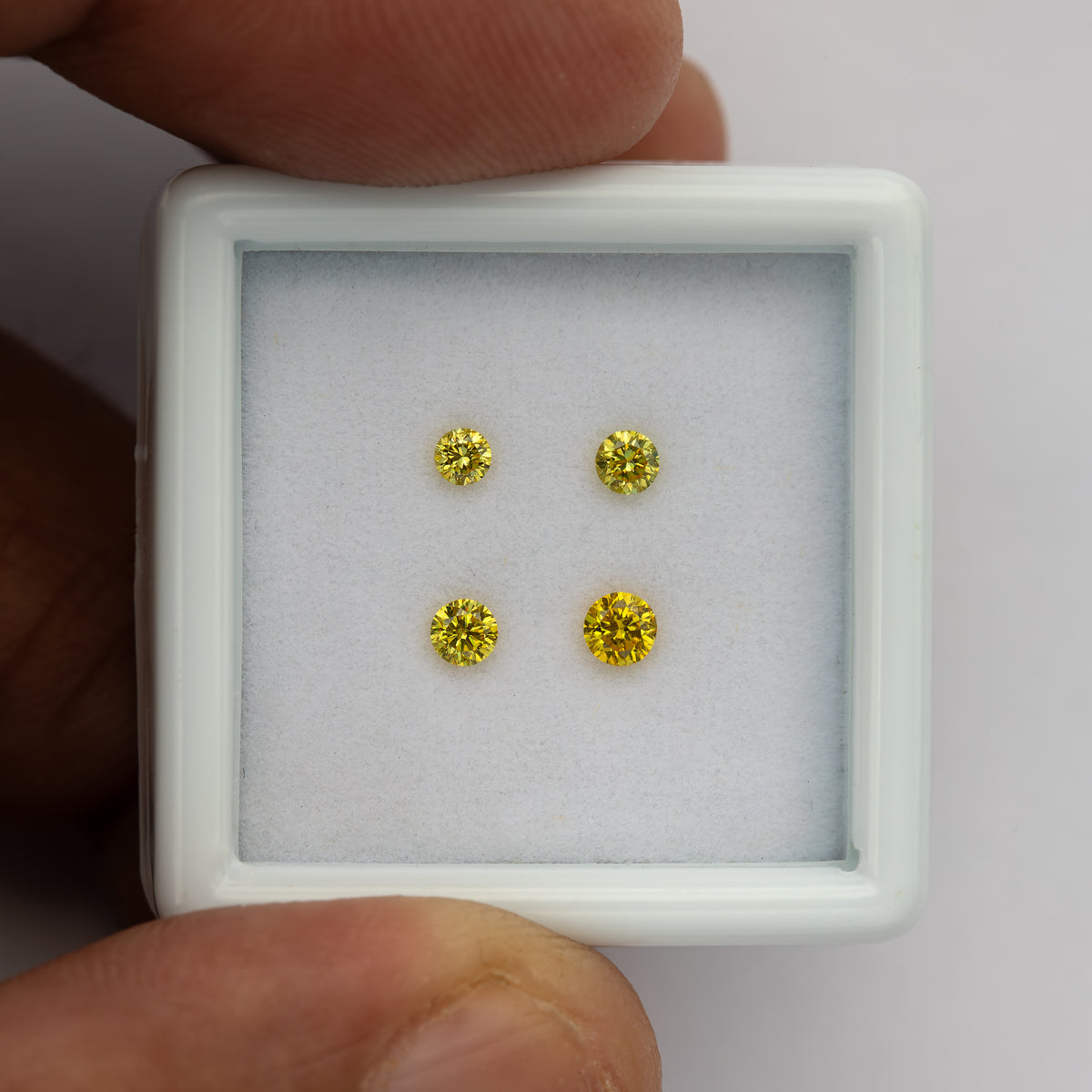 Close hand-held size view of the four yellow diamonds and tray rim.