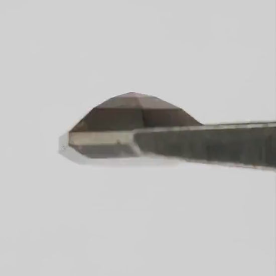 H279 dark brown diamond moving between fingertips, showing both faceted faces, warm reflections and realistic scale.