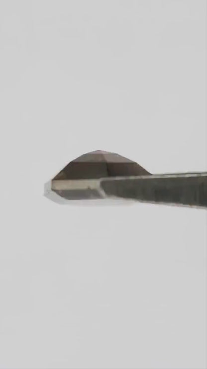 H279 dark brown diamond moving between fingertips, showing both faceted faces, warm reflections and realistic scale.
