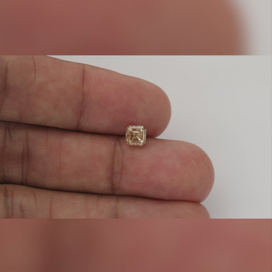 Champagne Asscher-cut natural diamond shown face-up on fingers at changing scales, with visible dark clarity characteristics.