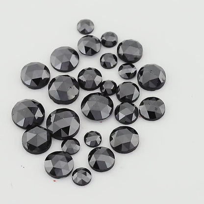 Moving views of a black round rose-cut diamond parcel, showing mixed sizes and facet reflections.