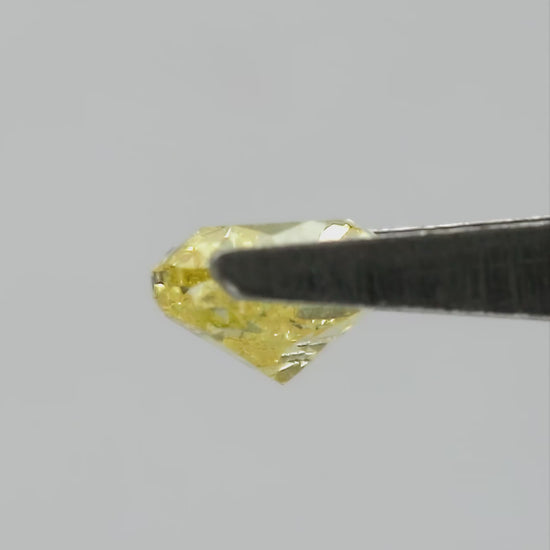 Yellow heart-shaped diamond rotating in tweezers, followed by fingertip views for scale.