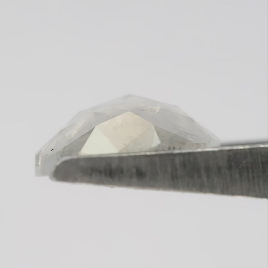 Finished video of the oval diamond rotating in metal tweezers, followed by fingertip scale, taken in natural light.