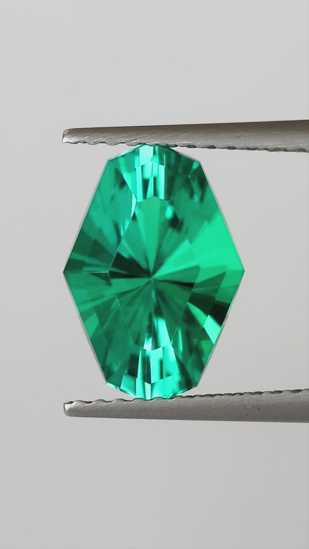 Natural-light finished video of the representative BLS200 green lab-grown emerald, showing face-up, reverse and finger scale views.