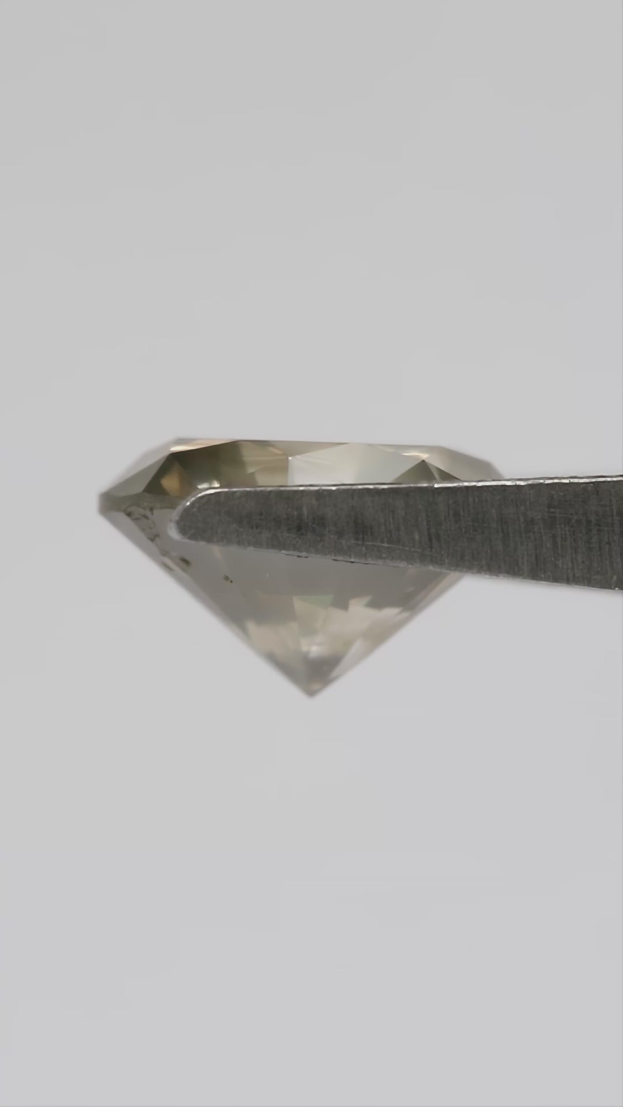 KL444 natural diamond turning in tweezers, showing face-up reflections, side and pavilion views, followed by views on the hand for scale.