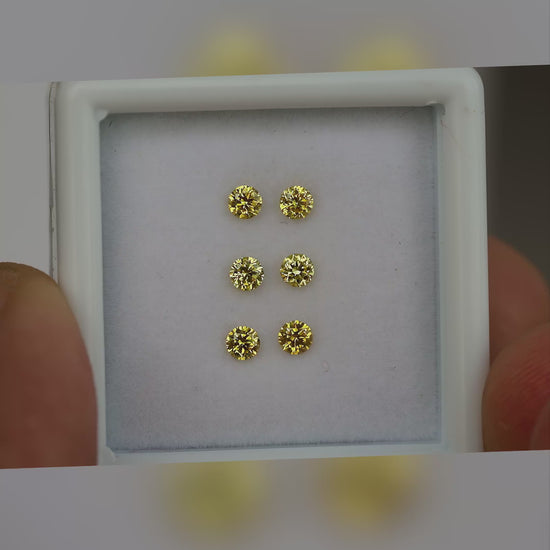 Natural canary yellow diamonds shown in motion; purchase contains only the selected pair or individual diamond.