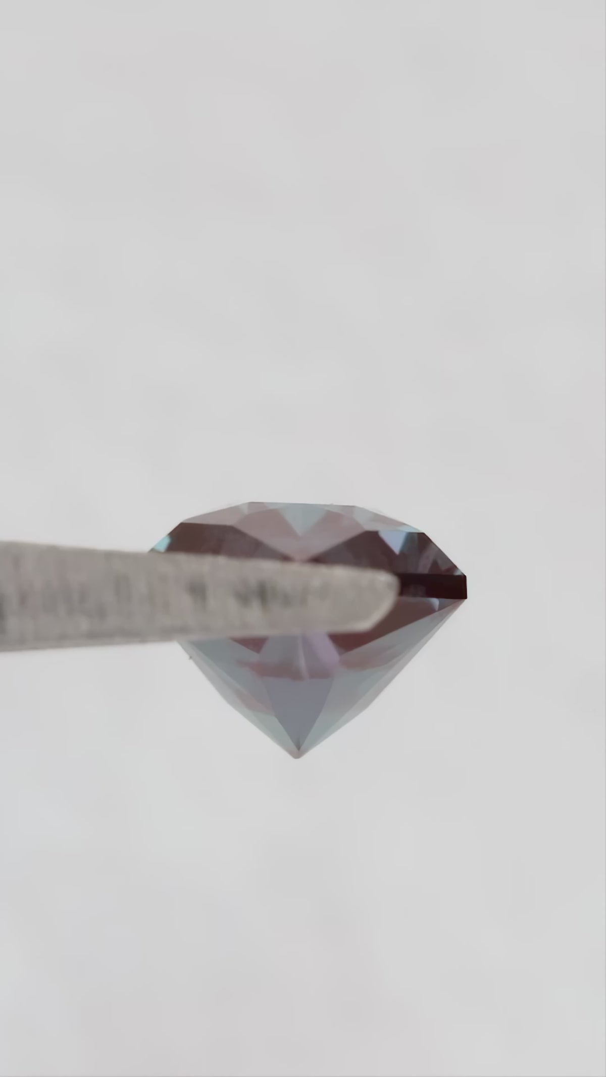 Video of BLS112 in tweezers, showing its facets and color response as the viewing angle changes.