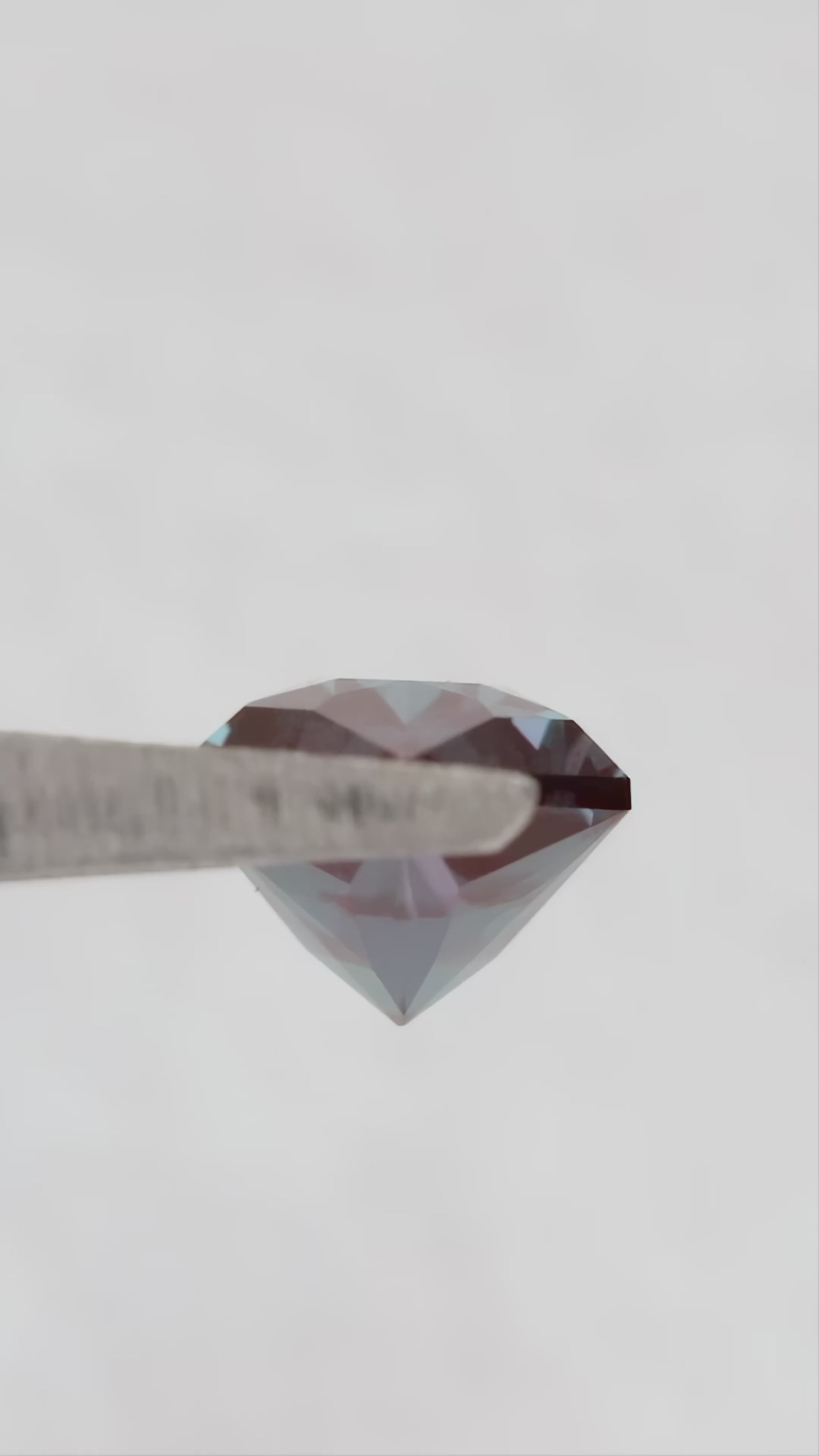 Video of BLS112 in tweezers, showing its facets and color response as the viewing angle changes.