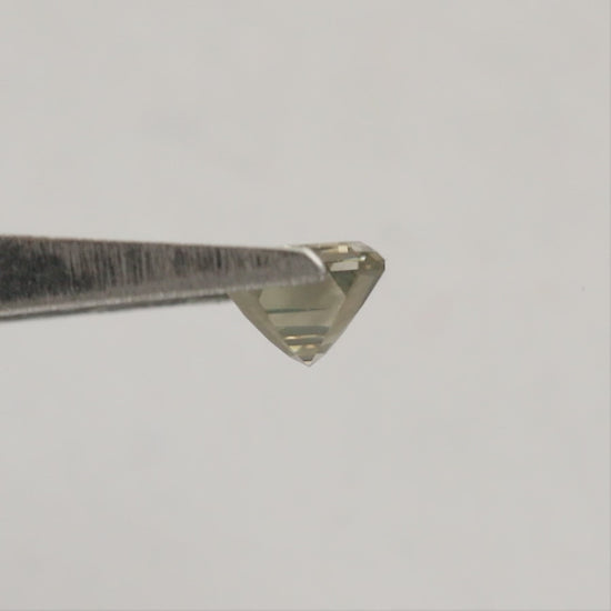 Emerald-cut diamond rotating in tweezers from crown to reverse views, followed by horizontal fingertip views showing its scale.