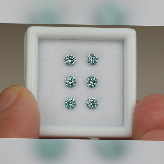 Video of six blue diamonds in a held white display box, with close face-up views and relative-scale context.