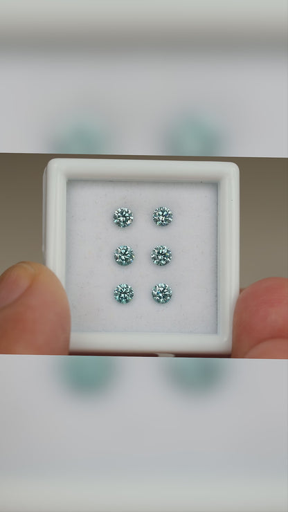 Video of six blue diamonds in a held white display box, with close face-up views and relative-scale context.