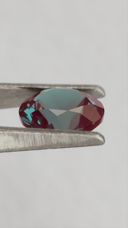 Merchant-finished natural-light video of the round lab-grown alexandrite design, including crown, back and fingertip-scale views.