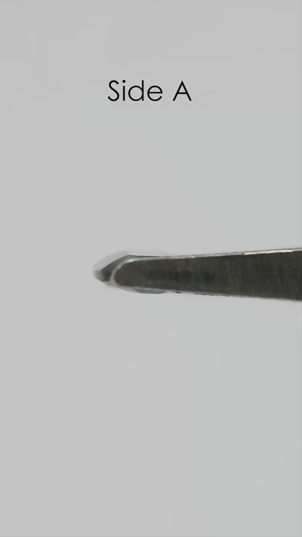 Natural-light rotation and fingertip-scale video of the exact green-blue portrait-cut sapphire.