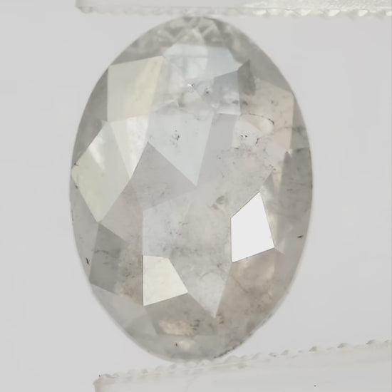 Finished video of the oval diamond rotating in pale tweezers, showing crown reflections in natural light.