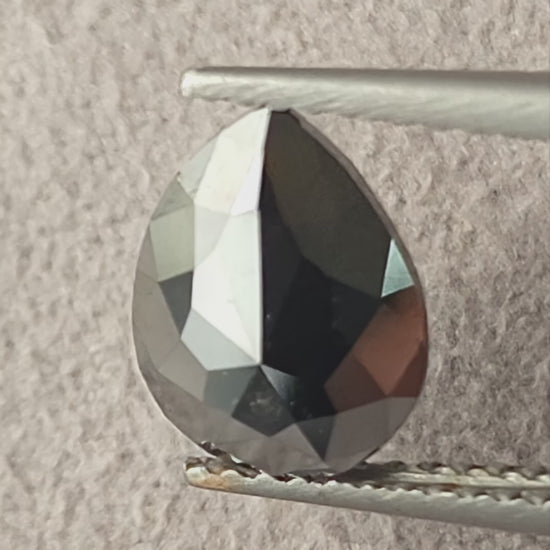 Video of the exact 1.63 carat pear rose-cut color-enhanced black natural diamond BKK-4, showing its outline and changing facet reflections as it moves.