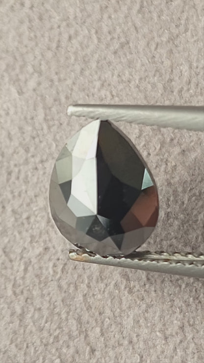 Video of the exact 1.63 carat pear rose-cut color-enhanced black natural diamond BKK-4, showing its outline and changing facet reflections as it moves.