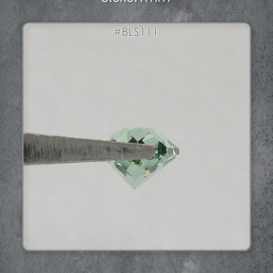 Video of BLS111 mint green lab-grown sapphire in tweezers, showing its facets and reflections as the viewing angle changes.