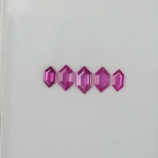 The complete five-ruby parcel shown in changing face-up and tilted tray views.