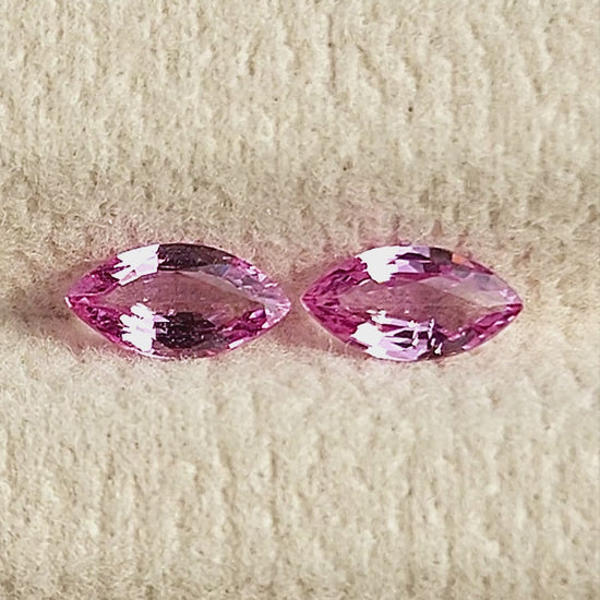 Both pink marquise sapphires shown together in changing face-up pad views and between fingertips for scale.