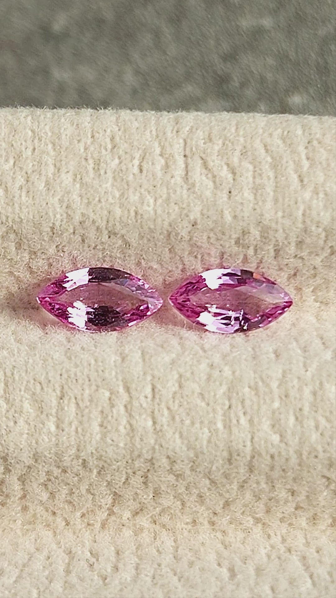 Both pink marquise sapphires shown together in changing face-up pad views and between fingertips for scale.