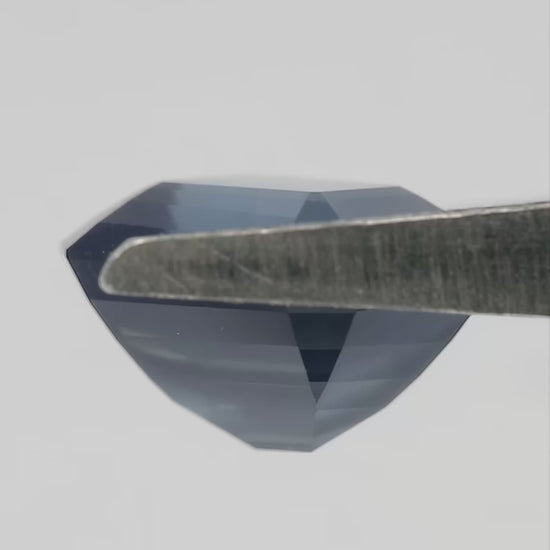 Video of the exact sapphire rotating between tweezers and on fingertips,, showing face-up color, profile, pavilion and scale.