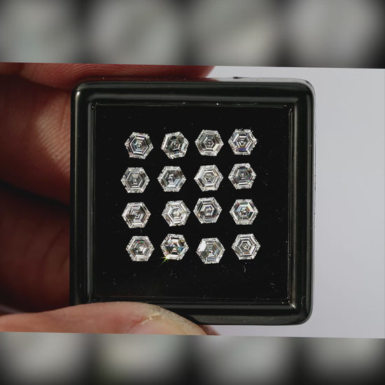 Video of hexagonal step-cut diamonds arranged face-up in a black tray held between fingers, with wider scale views and closer views of changing facet reflections.