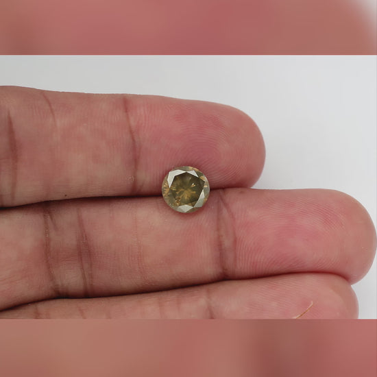 Face-up 4K video of the exact KL446 olive-brown round brilliant diamond in tweezers, showing its facet pattern, color shifts and visible I1 clarity features.