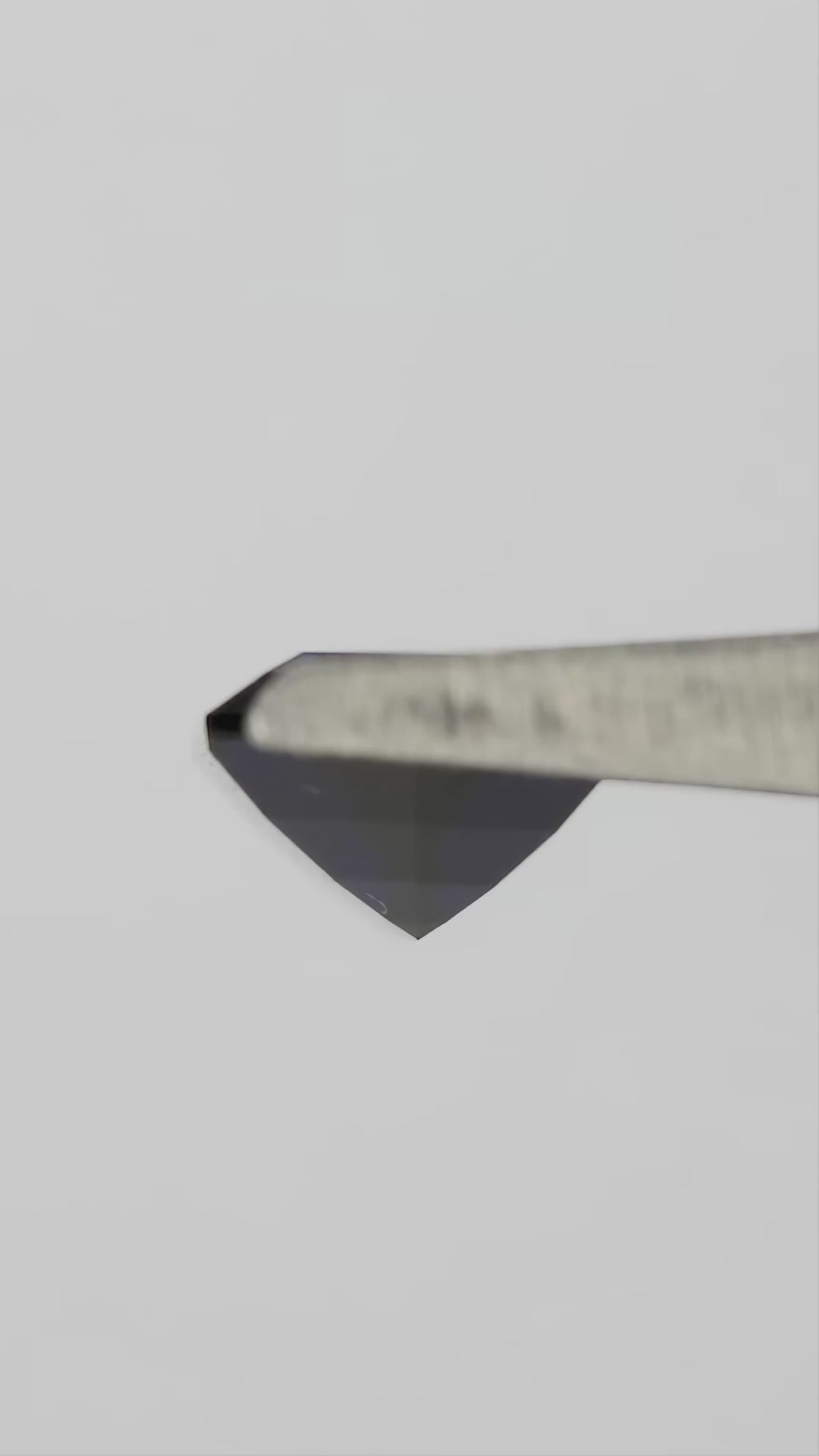 Natural-light rotation and fingertip-scale video of the representative royal-blue lab-grown hexagonal step-cut sapphire.